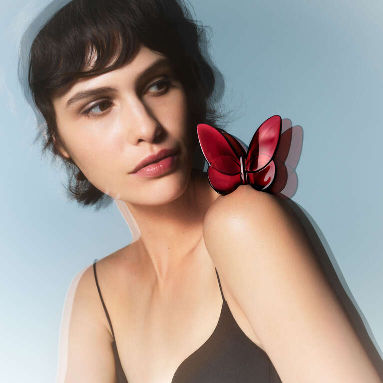 Woman with a crystal butterfly on her shoulder